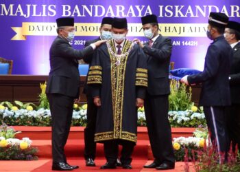 HASNI Mohammad (kiri) menyempurnakan upacara pemakaian jubah, kalung dan songkok kepada Mohd Haffiz Ahmad di Dewan Serbaguna MBIP, Skudai, Johor.