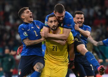 GIANLUIGI Donnarumma (tengah) diraikan rakan-rakan sepasukannya ketika menyelamatkan dua sepakan penalti England untuk membantu Itali muncul juara Euro 2020, Isnin lalu. - AFP