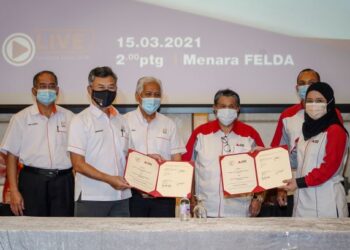 Pengarah Besar Felda, Datuk Amiruddin Abdul Satar (dua dari kiri) dan Ketua Pegawai Eksekutif Agrobank, Khadijah Iskandar bertukar dokumen perjanjian kerjasama disaksikan oleh Idris Jusoh (tiga dari kiri) dan Mustapha Buang (dua dari kanan) di Menara Felda, Kuala Lumpur, semalam. – utusan/FARIZ RUSADIO