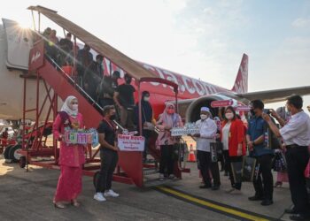 ARIFFIN Deraman (empat, dari kanan) menyambut ketibaan seramai 59 penumpang pesawat AirAsia AK5310 dari Kota Kinabalu ke Kuala Terengganu di Lapangan Terbang Sultan Sultan Mahmud di Kuala Nerus hari ini. - UTUSAN/PUQTRA HAIRRY ROSLI