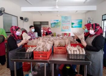 PARA pekerja Nasi Berlauk Kak Chik melakukan kerja-kerja membungkus mengikut syif masing-masing sebelum diedarkan kepada pelanggan di dalam mahupun luar Kelantan.