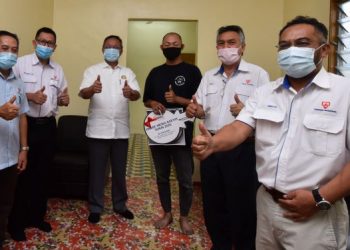 Hasni Mohammad (tiga dari kiri) bersama penerima rumah PMR TNB Peringkat Negeri Johor 2020, Ng Kim Sia (tiga, kanan) di Kampung Lama, Pontian minggu lalu.