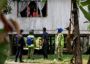 PEGAWAI Kesihatan di samping polis dan Jabatan Sukarelawan Malaysia (Rela) menggempur rumah penduduk yang enggan melakukan ujian saringan bersasar Covid-19 di Kampung Seberang Baruh di Kuala Terengganu hari ini. - UTUSAN/PUQTRA HAIRRY ROSLI