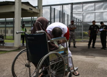 AMIR mencium tangan ibunya yang berkerusi roda ketika berpeluang bersua muka ketika program Jalinan Kasih sempena Aidilfitri Penjara Pokok Sena. -UTUSAN/SHAHIR NOORDIN