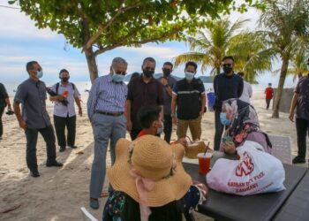 DR. MAHATHIR Mohamad beramah mesra dengan pengunjung di Pantai Chenang, Langkawi.