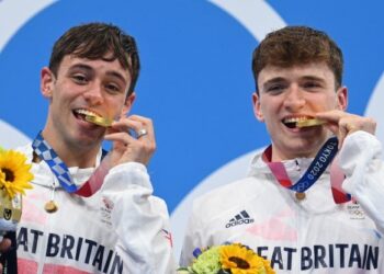 Thomas Daley dan Matty Lee menggigit pingat selepas meraih  emas 10 meter platform seirama.