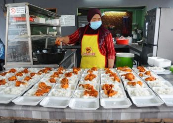 HASHIMAH Md. Noor tidak menang tangan menyediakan makanan yang ditempah untuk diedarkan kepada mangsa banjir di PPS SMK Taman Kota Jaya, Kota Tinggi, Johor hari ini. - FOTO/ RAJA JAAFAR ALI