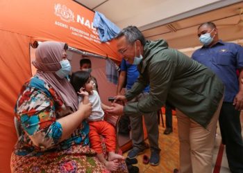 HASNI Mohammad bermesra dengan seorang kanak-kanak mangsa banjir ketika meninjau PPS di Sekolah Kebangsaan Laksamana, Kota Tinggi, Johor hari ini.