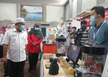 Alias (kiri) melawat gerai pameran dalam  Program Sukarelawan Komuniti Sihat Pembina Negara (Kospen) Terengganu dan Sambutan Hari Jantung Sedunia Peringkat Kebangsaan di Dewan Majlis Daerah Hulu Terengganu, di Kuala Berang, Hulu Terengganu hari ini.-UTUSAN/NOOR HAYATI MAMAT