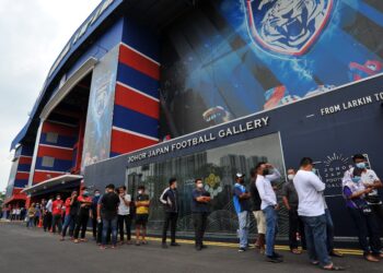 PENYOKONG JDT sanggup beratur panjang untuk membeli jersi pasukan di Stadium Larkin hari ini. - UTUSAN/RAJA JAAFAR ALI