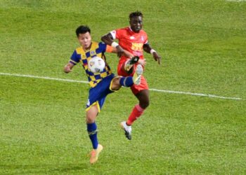 MUSLIM Ahmad (kiri) diasak pemain Sabah dalam perlawanan di Stadium Darul Makmur di Kuantan malam ini.
UTUSAN/SHAIKH AHMAD RAZIF