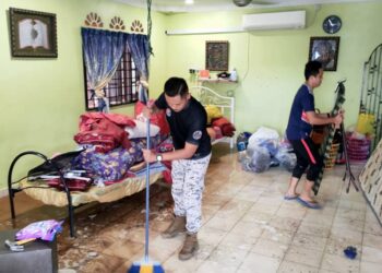 SEBAHAGIAN anggota Maritim Malaysia membantu membersihkan rumah pegawai yang terkesan di Taman Jenderam Aman, Sepang, Selangor. - FOTO MARITIM MALAYSIA