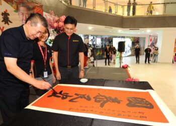 SALAHUDDIN AYUB menulis kaligrafi yang memberi maksud Negara Makmur Rakyat Sejahtera semasa merasmikan pertandingan kaligrafi sempena Tahun Baharu Cina di pusat beli-belah Paradigm Mall, Johor Bahru.