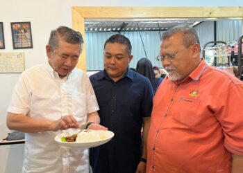 SALAHUDDIN AYUB (kiri) menunjukkan nasi paprik ayam yang dijual dengan harga RM5 di Restoran Wachaa Parit Raja, Batu Pahat.