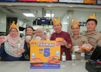 SALAHUDDIN AYUB (tengah) dan Fuziah Salleh (kiri) menunjukkan Burger Rahmah yang dijual pada harga RM5 di Restoran Burger King di Taman Bukit Indah, Johor Bahru.