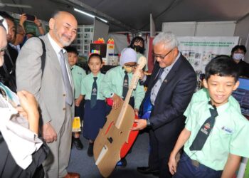 NOORAZAM OSMAN (dua dari kanan) melihat alat muzik yang dihasilkan daripada bahan kitar semula oleh murid-murid Sekolah Kebangsaan Taman Suria ketika melawat pameran sempena Majlis Perasmian Sudut Lestari MBJB di Perpustakaan Sultan Ismail, Johor Bahru.