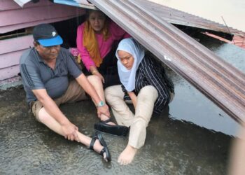 AZIZAH BANI dan keluarganya berlindung di atas bumbung rumahnya di Jalan Sidek, Kampung Jawa, Chaah, Segamat sementara menunggu bantuan tiba.