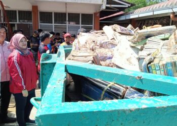 FADHLINA SIDEK melihat timbunan buku yang rosak akibat banjir di PPS SK Seri Bali, Chaah, Segamat.