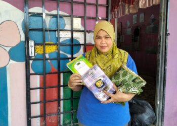 AZIZAH BANI menunjukkan sejadah, buku surah Yasin serta kain pelikat yang tidak rosak dan basah selepas rumahnya di Kampung Jawa, Chaah, Segamat ditenggelami banjir.