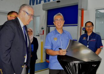 TENGKU ZAFRUL TENGKU ABDUL AZIZ menurunkan tandatangan pada bilah kapal terbang semasa melakukan lawatan ke  Repair Sdn. Bhd., di Iskandar Puteri.