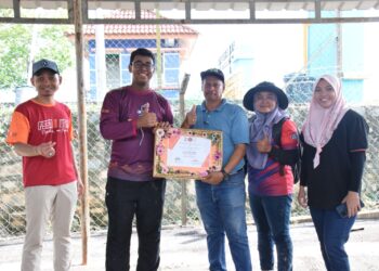 PIHAK UTM menerima penghargaan daripada Pengurus Felda Maokil 1, Ibrahim Daud (tengah) atas inisiatif membantu mangsa banjir di kawasan Felda berkenaan.