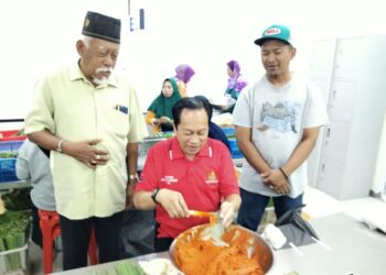 AHMAD MASLAN cuba membungkus otak-otak semasa melawat sebuah kilang yang mengusahakan produk tersebut di Pontian Besar, Pontian.