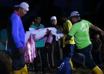 THEIN KO HTUT mengangkat jenazah anaknya untuk disemadikan di Tanah Perkuburan Islam Bakri, Batu 6, Muar.