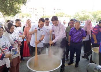 MOHD. HAIRI MAD SHAH (tengah) dan Andrew Chen Kah Eng mengacau bubur lambuk semasa menghadiri Program Bubur Lambuk Orang Muda Johor di PPR Seri Stulang, Johor Bahru.