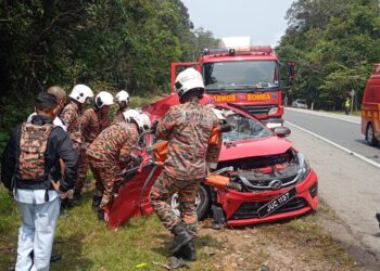 ANGGOTA bomba mengeluarkan pemandu Perodua Myvi yang tersepit dalam kemalangan di Jalan Mersing Batu 10, Mersing.