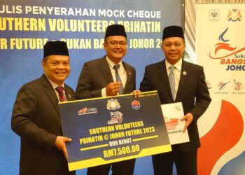 HASNI MOHAMMAD (kanan) menerima replika cek Southern Volunteers Prihatin daripada Mohd. Hairi di Kota Iskandar, hari ini.