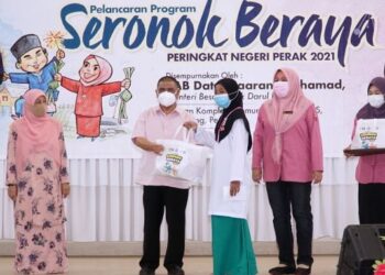 SAARANI Mohamad (dua dari kiri) menyampaikan baju raya kepada Nuraina Rahimah Mohd. Rahim pada Program Seronok Beraya di Lenggong. - UTUSAN/ZULFACHRI ZULKIFLI