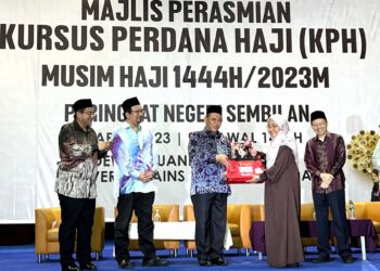 AMINUDDIN HARUN (tiga dari kiri) dan Nurrin Anuwar (kanan) menyerahkan beg kepada sebahagian bakal jemaah haji pada Majlis Perasmian Penutup Kursus Perdana Haji Negeri Sembilan 1444H/2023M di Dewan Tuanku Canselor, USIM di Nilai, Seremban hari ini.-UTUSAN/ZAKKINA WATI AHMAD TARMIZI.