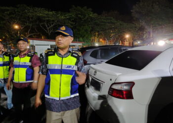 LOKMAN Jamaan (kanan) menunjukkan sebahagian daripada 14 buah kereta yang disita kerana dijadikan kenderaan sewa tanpa permit sah dalam operasi di Langkawi. -UTUSAN/NUR AMALINA AZMAN