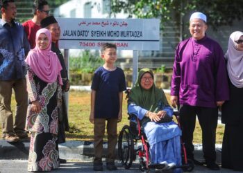 AHLI keluarga Allahyarham Datuk Syeikh Mohd. Murtadza termasuk isteri Allahyarham, Datin Lily Sidek (berkerusi roda) bergambar di hadapan papan tanda nama baharu Jalan Sikamat yang digantikan dengan nama Jalan Dato’ Syeikh Mohd Murtadza pada majlis pelancaran nama jalan tersebut di Seremban hari ini.-UTUSAN/MOHD. SHAHJEHAN MAAMIN.