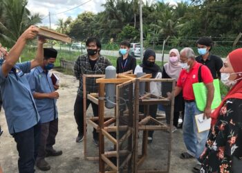 Sebahagian pelajar dan tenaga pengajar melihat reka bentuk modul sistem pertanian bandar yang  dibangunkan di Batu Pahat, Johor.