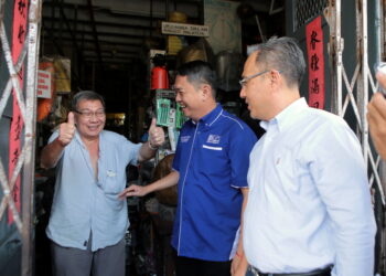 TAN Chee Hiong (tengah) bersama Naib Ketua UMNO Bahagian Alor Setar, Syed Hafiz Syed Mustapa (kanan) menyantuni peniaga di Pekan Cina ketika mengadakan tinjauan mesra di Alor Setar. -UTUSAN/SHAHIR NOORDIN