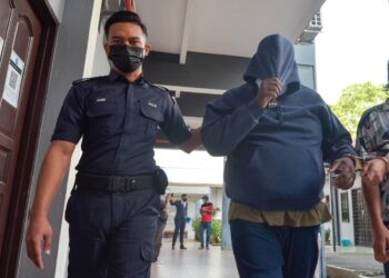 MUHAMMAD Fairus Mohammad Ali Raminidass (kanan) dibawa keluar dari mahkamah selepas dituduh menipu syarikat insurans berhubung tuntutan insurans kemalangan jalan raya dua tahun lalu di Mahkamah Majistret Ipoh hari ini. - UTUSAN/ZULFACHRI ZULKIFLI