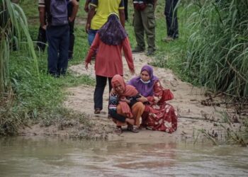 IBU kepada kanak-kanak yang dihanyutkan arus sungai semalam, Maizatul Nadia Zulkifli menunggu di tepi tebing ketika pasukan penyelamat menjalankan operasi mencari anaknya di Ipoh hari ini. - FOTO/ASLIZA MUSA