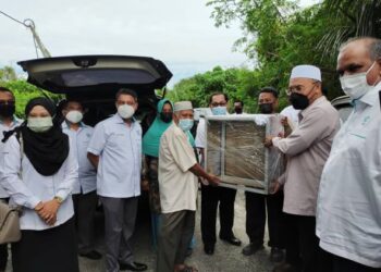 IDRIS Ahmad (dua dari kanan) menyerahkan peralatan perniagaan kepada Azidi Sudin (tiga dari kanan) penerima MyHaus YaPEIM Perak di Kampung Seri Aman, Menglembu di Ipoh hari ini. - FOTO/ASLIZA MUSA