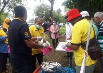 SEBAHAGIAN penduduk beratur untuk menerima sumbangan ikan kembung daripada Perkasa Parlimen Kuala Kedah di Taman Wira Mergong, Alor Setar hari ini.