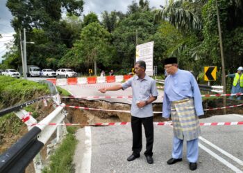 MOHAMMAD Nizar Jamaluddin (kanan) bersama Pengarah JKR, Hamdan Ali (kiri) meninjau Jambatan Enggor yang runtuh semalam akibat hujan lebat dan arus deras Sungai Enggor di Sungai Siput hari ini. - UTUSAN