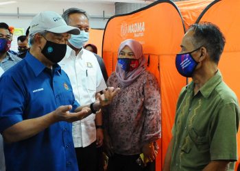 MUHYIDDIN Yassin bertanya khabar kepada  mangsa banjir sambil diperhatikan oleh Menteri Besar Johor Datuk Hasni Mohamed (dua dari kiri) ketika mengadakan lawatan di PPS SK Laksamana disini. UTUSAN/RAJA JAAFAR ALI