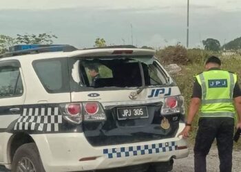 SEORANG anggota JPJ melihat kenderaan SUV yang kemek di bahagian belakang selepas dirempuh lori semalam.