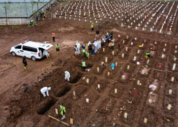 KEADAAN di salah sebuah tanah perkuburan di Jakarta yang mana para petugas bertungkus lumus mengebumikan mangsa Covid-19. - AFP