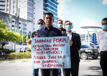 JAMAL Md Yunos menunjukkan poster  selepas memberi keterangan di Ibu Pejabat Polis Bukit Aman, Kuala Lumpur, hari ini. - UTUSAN/ SHIDDIEQIIN ZON