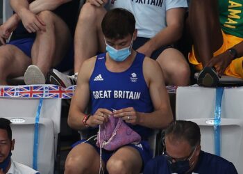 Tom Daley sempat mengait baju sambil menonton saingan akhir acara 3 meter papan anjal wanita yang turut disertai penerjun Malaysia, Nur Dhabitah Sabri semalam.