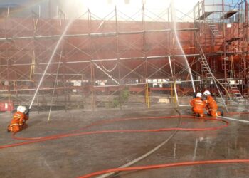 ANGGOTA bomba memadam kebakaran kapal peronda milik Maritim Malaysia ketika kapal itu dalam penyelenggaraan di Kampung Baru, Sitiawan petang tadi. - UTUSAN/