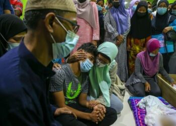 MUHAMMAD Syafiq Ahmad tidak dapat menahan sebak dan ditenangkan oleh ahli keluarganya ketika menatap jenazah ibu mentua dan anaknya buat kali terakhir di Kampung Padang Pusing, Pendang, Kedah.