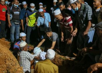 MUHAMMAD Syafiq Ahmad menurunkan jenazah anaknya, Muhammad Aisy Saqeef untuk dikebumikan dalam satu liang lahad bersama jenazah ibu mentuanya di Tanah Perkuburan Islam Bukit Murai, Kampung Padang Pusing, Pendang malam ini. - UTUSAN/SHAHIR NOORDIN