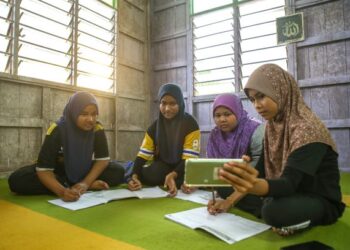 PELAJAR tahun enam Sekolah Kebangsaan Telaga Mas, dari kiri Qaseh Hanis Jamila Haswari, Nurul Fatihah Sajidah Mohd Azhar, Nur Izzati Nuha Mohd Zubir dan Nur Anis Humaira Mohd Zamri terpaksa menumpang di sebuah surau bagi mengikuti kelas pembelajaran dalam talian berikutan masalah capaian internet yang teruk  di Kampung Bukit Teriak, Pokok Sena hari ini. Perkarangan surau merupakan satu satunya kawasan di kampung itu yang mempunyai capaian internet.
UTUSAN/SHAHIR NOORDIN